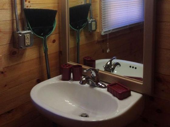White bathroom sink with a mirror above it and red soap dishes